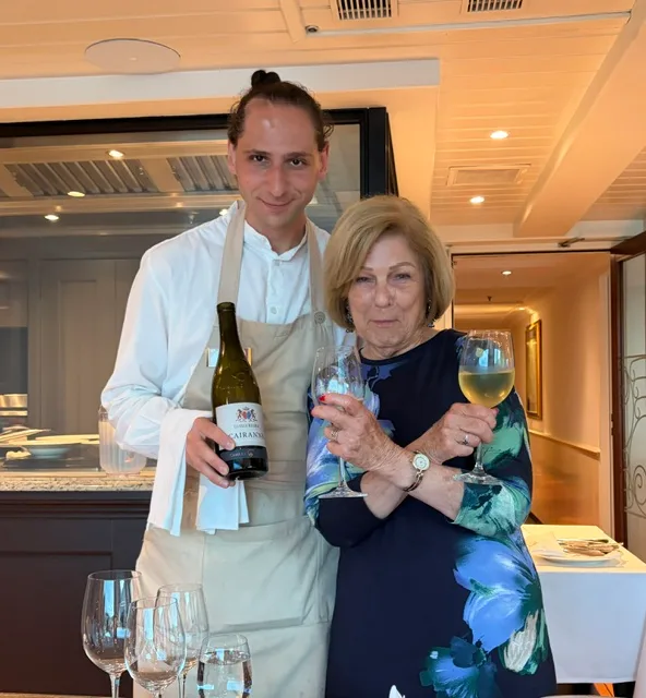 Marsha with the ship's chef and a glass of wine