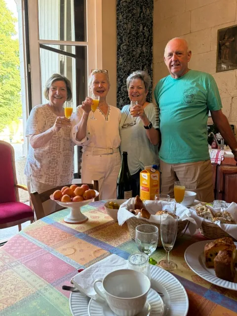 Four friends raising mimosas before breakfast