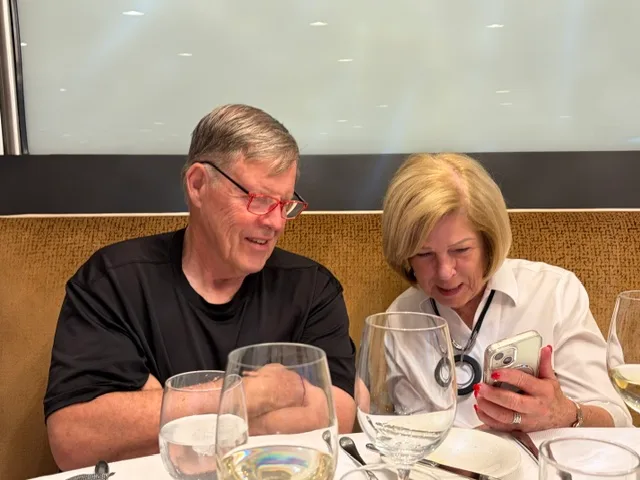 A couple sharing photos over dinner on board